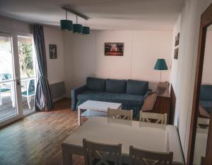 salon z kanapą i stołem w obiekcie Villas du lac w mieście Soustons