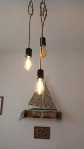 un lampadario a braccio con tre luci appese a un soffitto di Adriatica Apartments a Škrljevo