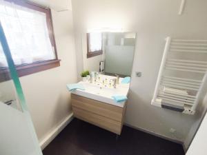 a bathroom with a sink and a mirror at Appartement Spacieux Schiltigheim in Schiltigheim