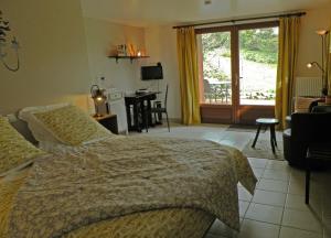 1 dormitorio con cama, escritorio y ventana en Maison Les Fraysses, en Bellefont-La Rauze