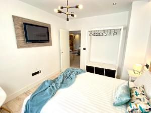 1 dormitorio con 1 cama y TV en la pared en People Homes Ponce 13, en Jerez de la Frontera