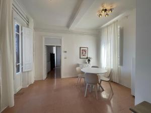 una sala da pranzo con tavolo e sedie bianchi di CASE BALDELLI LA TERRAZZA a Perugia