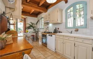 una cocina con electrodomésticos blancos y techos de madera. en Awesome Home In Frjus With Wifi, en Fréjus