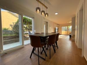 a dining room with a black table and chairs at Beach House Oliveglia (duplex house - 1st row to the sea) in Šilo