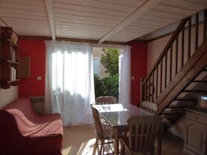 sala de estar con mesa y sillas y escalera en Maison de plage, en Narbonne-Plage
