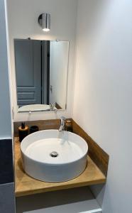 y baño con lavabo blanco y espejo. en La Bruyère en Rochefort-du-Gard