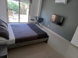 1 dormitorio con 1 cama y TV de pantalla plana en Modern Studio apartment Armonia Court en Paralimni