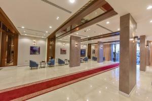 شقق الهدوء Alhudu Apartments في الرياض: لوبي فيه كراسي وطاولات في مبنى