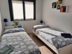 a bedroom with two beds and a window at Apartamento Dindurra Centro Playa in Gijón