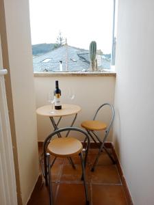 a small table with two chairs and a bottle of wine at Apartamento San Francisco in Viveiro