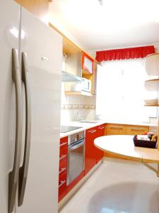 eine Küche mit einem weißen Kühlschrank und roten Schränken in der Unterkunft Apartamento San Francisco in Viveiro
