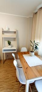 a dining room with a wooden table and white chairs at Apartament boBoski in Wadowice +7 photos