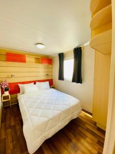 um quarto com uma grande cama branca e uma janela em Bungalow 4x3 em Burinhosa