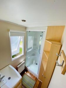 uma pequena casa de banho com um chuveiro e um lavatório. em Bungalow 4x3 em Burinhosa