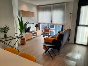 a living room with a couch and a table at Apartamento Dindurra Centro Playa in Gijón