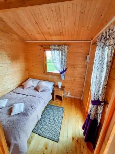 a bedroom with a bed in a wooden cabin at Pod Lawendą & Jacuzzi & Blisko Augustów in Augustów