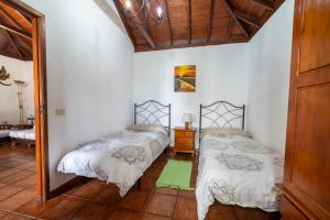 sypialnia z dwoma łóżkami w pokoju w obiekcie CASA CRUZ EL LLANO w mieście El Pinar