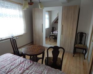 a bedroom with a table and chairs and a mirror at Talblick in Oberroßla