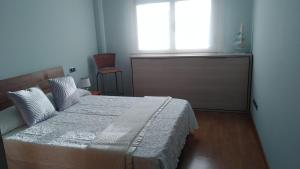 um quarto com uma cama grande e uma janela em Apartamento playa Cambrils Torresol 2 em Cambrils