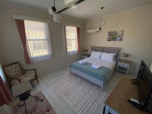 a bedroom with a bed and a chair and a television at Garden Palace Boutique Hotel in Kuşadası