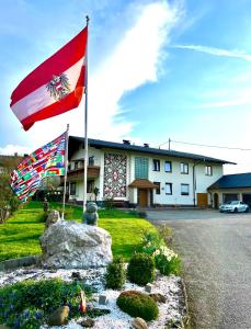 duas bandeiras estão a voar em frente a um edifício em Apartment 1 Gäste em Schörfling am Attersee