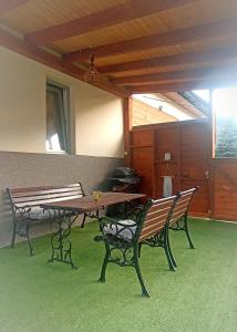 a patio with two benches and a table and a grill at U Beaty, niezależne mieszkania do wynajęcia in Ochotnica Górna
