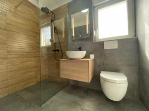W łazience znajduje się toaleta, umywalka i prysznic. w obiekcie Beach House Oliveglia (duplex house - 1st row to the sea) w mieście Šilo