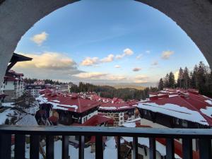 a view of a town in the snow from a balcony at Zornica Guest House in Chepelare