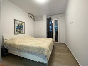 Mali Robit Apartments في غوليم: غرفة نوم بسرير في غرفة بيضاء
