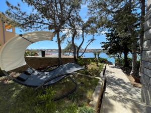 a metal object sitting on the grass next to a sidewalk at Beach House Oliveglia (duplex house - 1st row to the sea) in Šilo