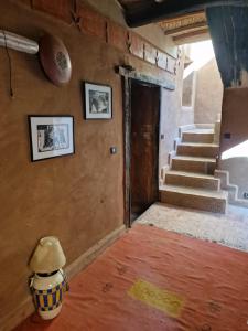 a room with stairs and a vase on the floor at Kasbah des montagnes maison d'h&ocirc;tes in Bou Tharar