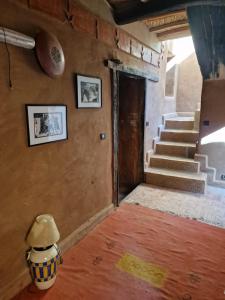 una stanza con scale e un vaso sul pavimento di Kasbah des montagnes maison d'hôtes a Bou Drarar