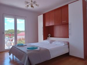 a bedroom with a bed and a large window at Francis Appartements in Pakoštane