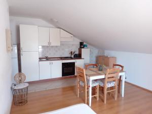 a kitchen and dining room with a table and chairs at Francis Appartements in Pakoštane