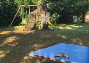 uma mesa de pingue-pongue num quintal com parque infantil em Gîte 2-4 couchages situé dans un magnifique jardin em Saint-Vivien