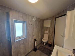 baño con aseo y ventana en Northern living 2 room with shared bathroom, en Tromsø