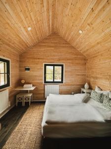 a bedroom with a large bed in a wooden wall at Karak Chalet in Izvoare