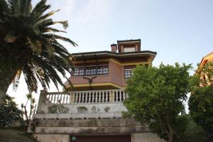 duży dom z balkonem i palmą w obiekcie Villa Marta w mieście Santillana del Mar
