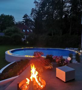 a fire pit in a yard next to a swimming pool at RETRO WILLA in Koronowo