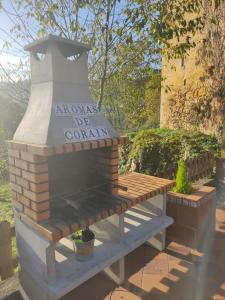 um forno de tijolos com um banco com um cartaz em Aromas de Coraín em Cangas de Onís