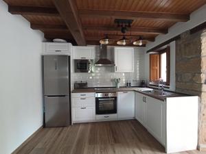 a kitchen with white appliances and a wooden ceiling at Aromas de Coraín in Cangas de Onís