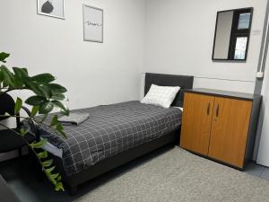 a bedroom with a bed and a wooden cabinet at Aleja "Solidarności" in Warsaw