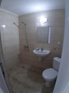 a bathroom with a toilet and a sink and a shower at Къща за гости WEST in Sunny Beach