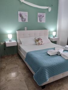 1 dormitorio con 1 cama blanca grande y paredes azules en Sophie's Village House, en Myrtos