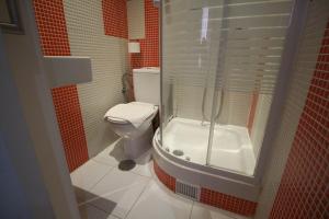 uma casa de banho com um WC e uma cabina de duche em vidro. em Hostal Foster em Madri