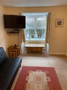 a living room with a couch and a table at Spacious 8 bed house Kirkby in Ashfield Nottingham in Kirkby in Ashfield