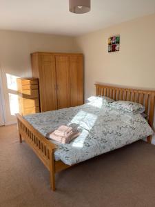 Spacious 8 bed house Kirkby in Ashfield Nottingham في Kirkby in Ashfield: غرفة نوم بسرير كبير مع اطار خشبي