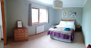 a bedroom with a bed and a television in it at Brackenbrae Holiday Cottage in Acharacle