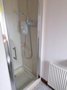 a shower with a glass door in a bathroom at Brackenbrae Holiday Cottage in Acharacle