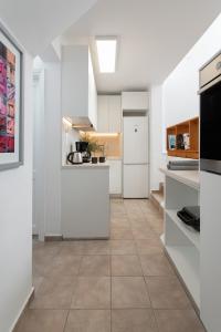 a kitchen with white appliances and a tile floor at Sunset Beach House with 2 bedrooms in Stelida